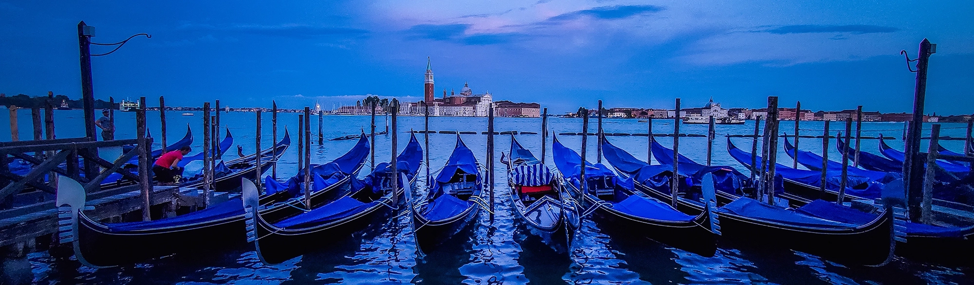 Gondolas moored by Saint Mark square with San Giorgio di Maggiore church in the background - Venice, Venezia, Italy, Europe
